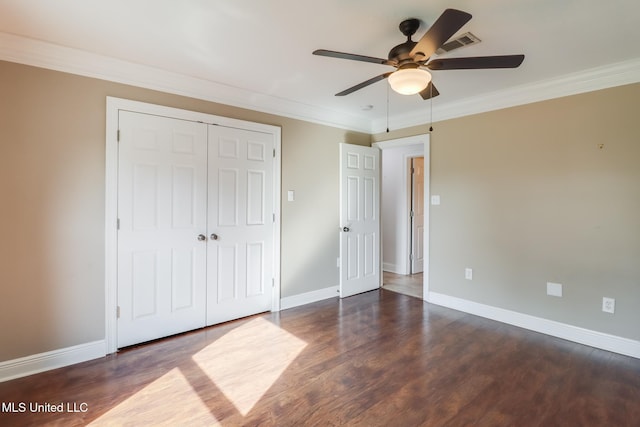 unfurnished bedroom with dark wood-type flooring, ceiling fan, ornamental molding, and a closet