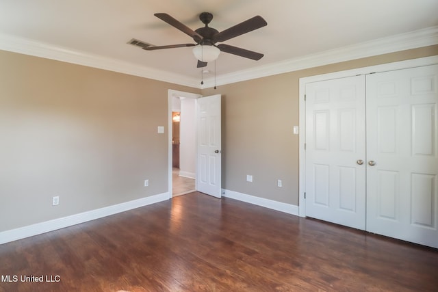 unfurnished bedroom with crown molding, dark hardwood / wood-style floors, ceiling fan, and a closet