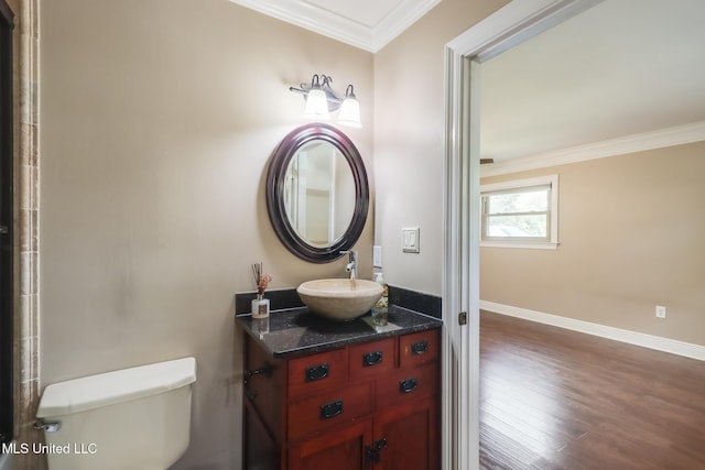 bathroom with ornamental molding, toilet, wood-type flooring, and vanity