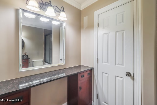 bathroom featuring vanity, ornamental molding, and toilet