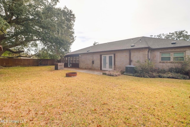 back of property featuring french doors, a yard, central air condition unit, and an outdoor fire pit