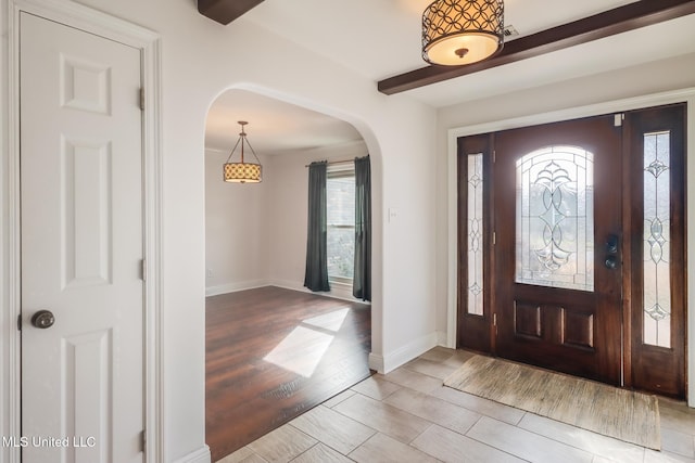 entryway with beam ceiling and light hardwood / wood-style floors