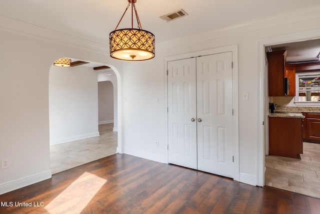 interior space with ornamental molding and dark hardwood / wood-style floors