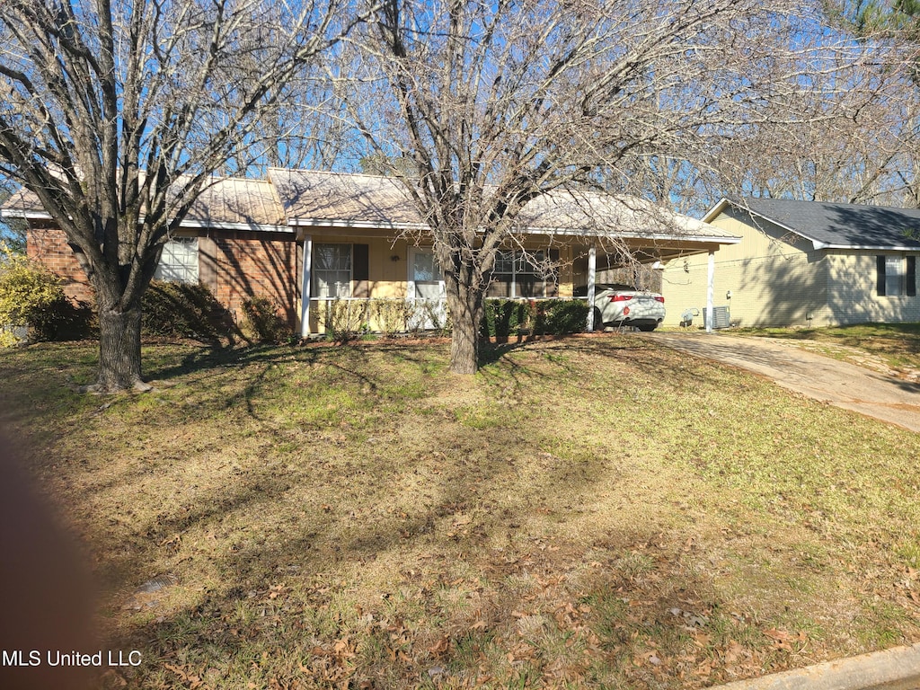 single story home featuring a carport, a front yard, and central AC unit