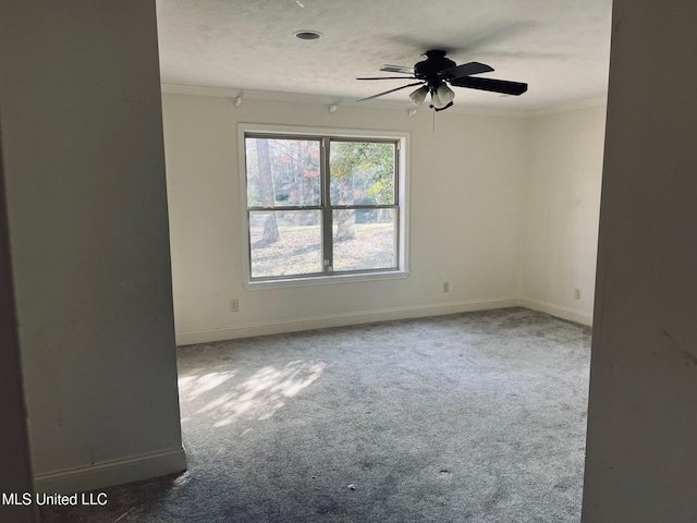 carpeted empty room with ceiling fan, ornamental molding, and a textured ceiling