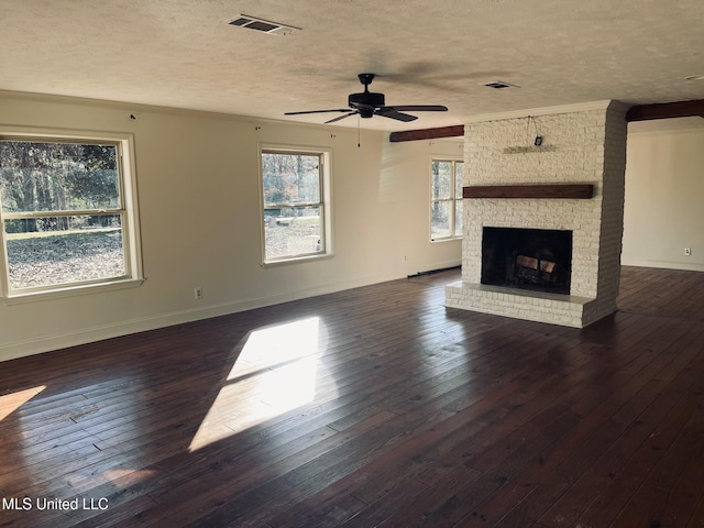 unfurnished living room with ceiling fan, a textured ceiling, a fireplace, and dark hardwood / wood-style flooring