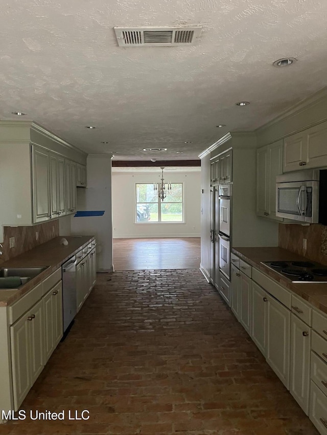 kitchen with crown molding, appliances with stainless steel finishes, sink, and a textured ceiling