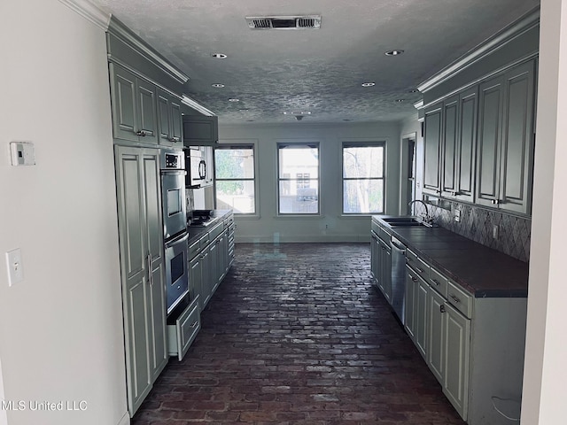 kitchen with sink, gray cabinets, a textured ceiling, and appliances with stainless steel finishes