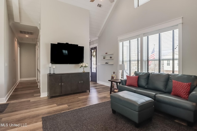 living room with dark wood-type flooring and high vaulted ceiling