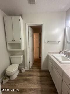6709 Caraway Rd, Moss Point, MS 39562 - bathroom with toilet, baseboards, visible vents, vanity, and wood finished floors