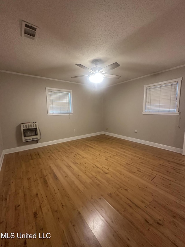 6709 Caraway Rd, Moss Point, MS 39562 - unfurnished room with visible vents, heating unit, a textured ceiling, and wood finished floors
