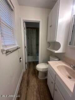 6709 Caraway Rd, Moss Point, MS 39562 - bathroom featuring toilet, baseboards, wood finished floors, and vanity