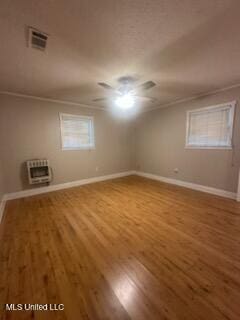 6709 Caraway Rd, Moss Point, MS 39562 - spare room featuring lofted ceiling, heating unit, baseboards, visible vents, and wood finished floors