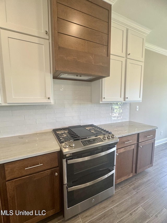 5322 Grays Valley Dr, Hernando, MS 38632 - kitchen with range with two ovens, light wood-type flooring, backsplash, crown molding, and white cabinets