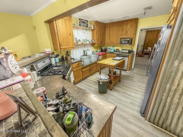 903 Kenwood Ln, Natchez, MS 39120 - kitchen with light hardwood / wood-style flooring, ornamental molding, kitchen peninsula, and appliances with stainless steel finishes