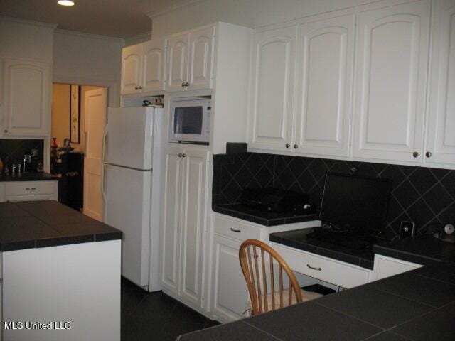 kitchen featuring backsplash, white cabinetry, and white appliances