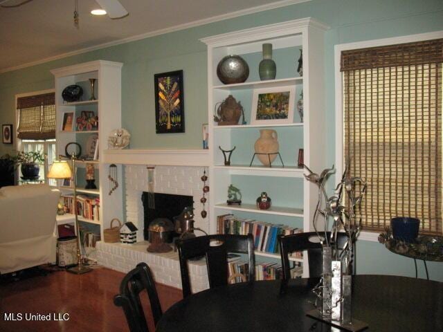 dining room with hardwood / wood-style floors, a brick fireplace, and ornamental molding