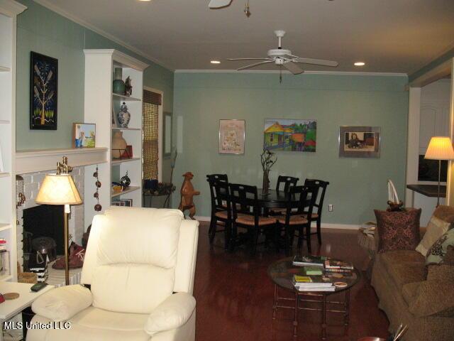 living room featuring hardwood / wood-style flooring, ceiling fan, and ornamental molding