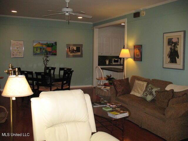 living room featuring crown molding and ceiling fan