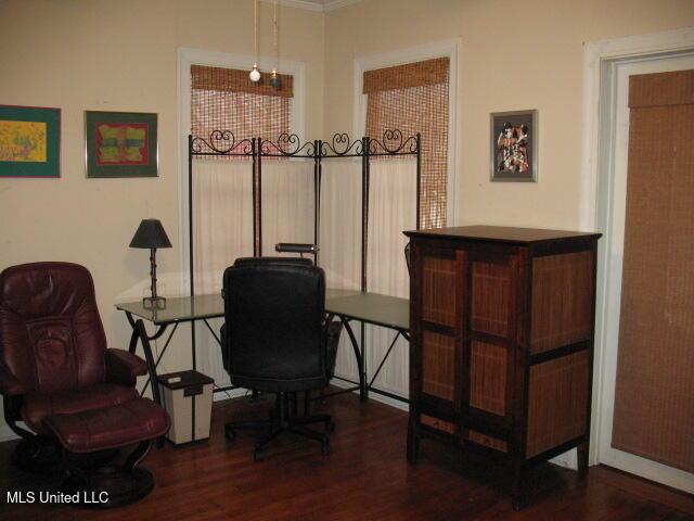 office space featuring dark wood-type flooring and ornamental molding