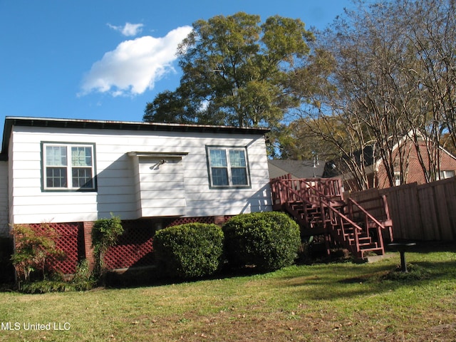 view of property exterior with a lawn and a wooden deck