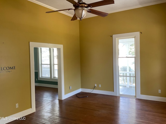 empty room featuring crown molding, ceiling fan, and dark wood-type flooring