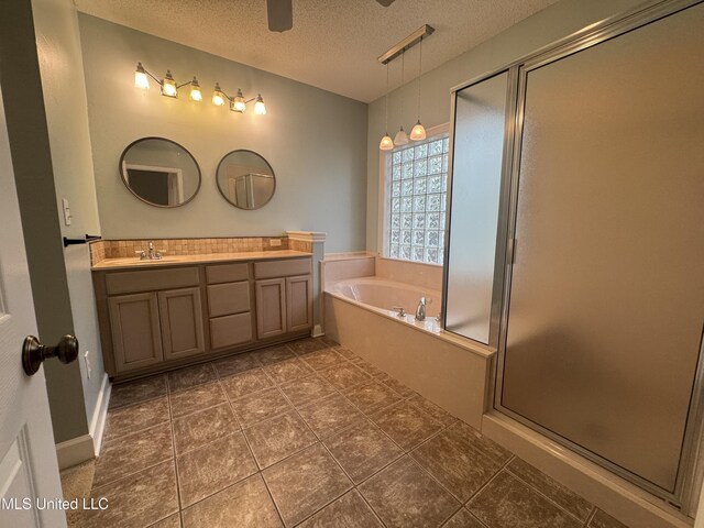 730 Ieke Cir, Diamondhead, MS 39525 - full bathroom featuring double vanity, a textured ceiling, a stall shower, a bath, and a ceiling fan