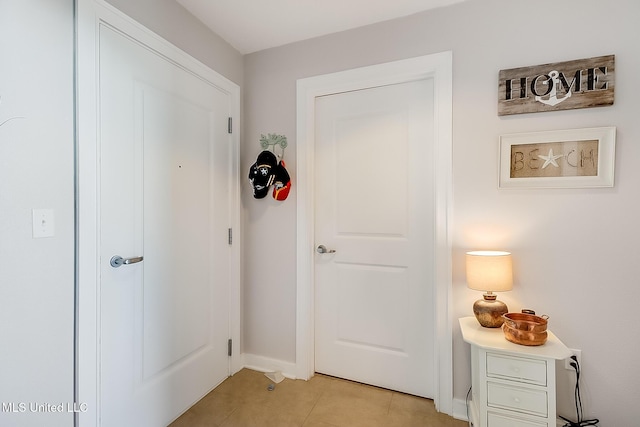 entryway featuring baseboards and light tile patterned floors