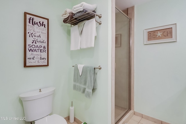 full bathroom featuring a stall shower, toilet, and tile patterned floors