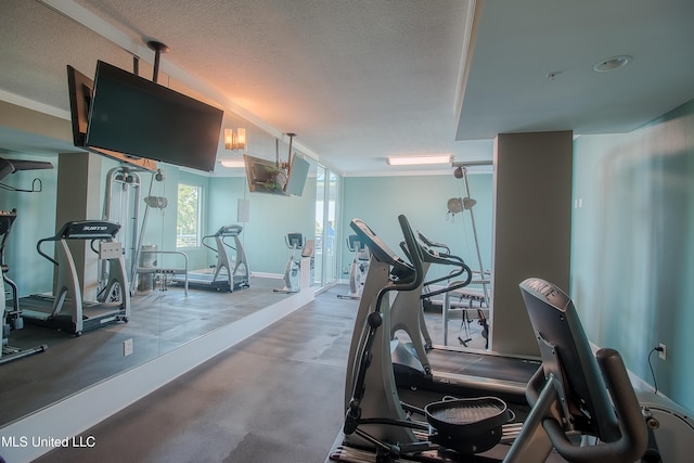 exercise room with baseboards, a textured ceiling, and ornamental molding