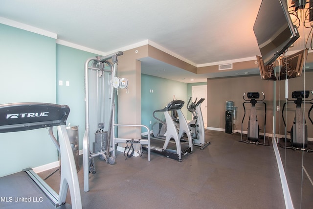 workout area featuring baseboards, visible vents, and ornamental molding