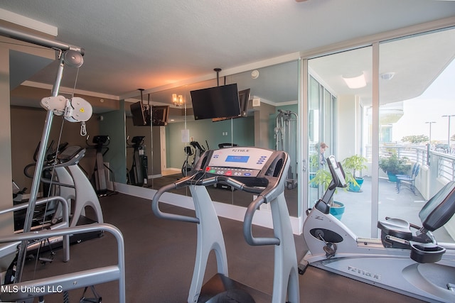 workout area featuring expansive windows and a textured ceiling