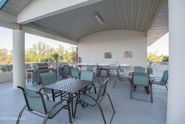 view of patio with outdoor dining space, a grill, a sink, and area for grilling