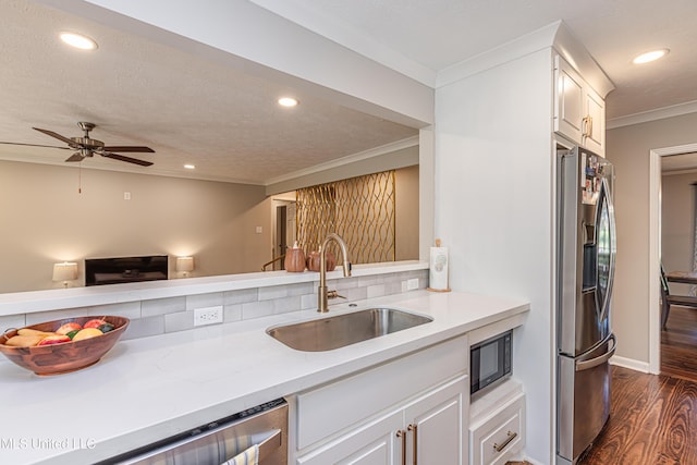 kitchen featuring dark wood-style floors, stainless steel appliances, recessed lighting, ornamental molding, and a sink