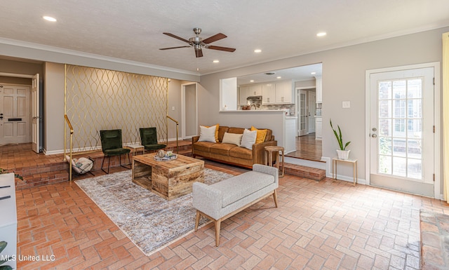 living room with baseboards, ornamental molding, brick floor, and recessed lighting