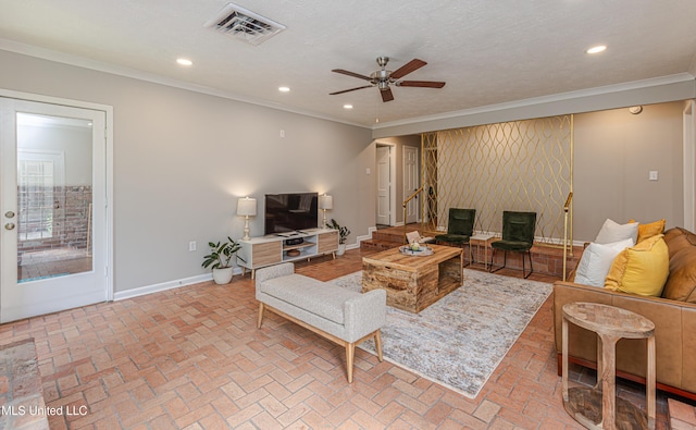 living area with baseboards, visible vents, crown molding, and recessed lighting