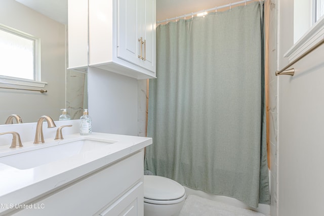 bathroom featuring curtained shower, vanity, and toilet