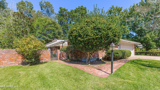 obstructed view of property featuring a garage, brick siding, fence, and a front lawn