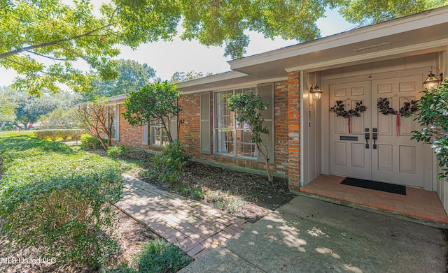 entrance to property featuring brick siding