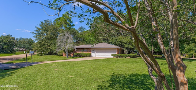 ranch-style house featuring an attached garage, a front lawn, and concrete driveway