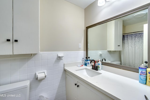 bathroom featuring toilet, tile walls, and vanity