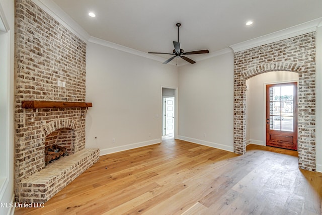 unfurnished living room with a fireplace, light hardwood / wood-style flooring, ceiling fan, and ornamental molding