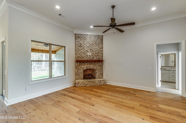 unfurnished living room featuring a fireplace, crown molding, and light hardwood / wood-style flooring