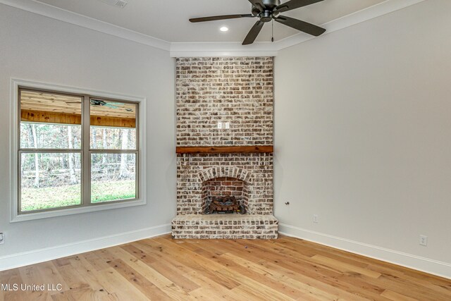 unfurnished living room featuring a brick fireplace, ceiling fan, wood-type flooring, and ornamental molding