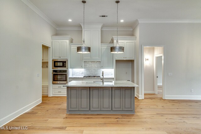 kitchen featuring an island with sink, light hardwood / wood-style floors, and appliances with stainless steel finishes