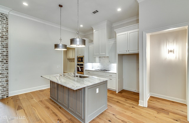 kitchen featuring white cabinetry, a kitchen island with sink, light hardwood / wood-style floors, and stainless steel appliances