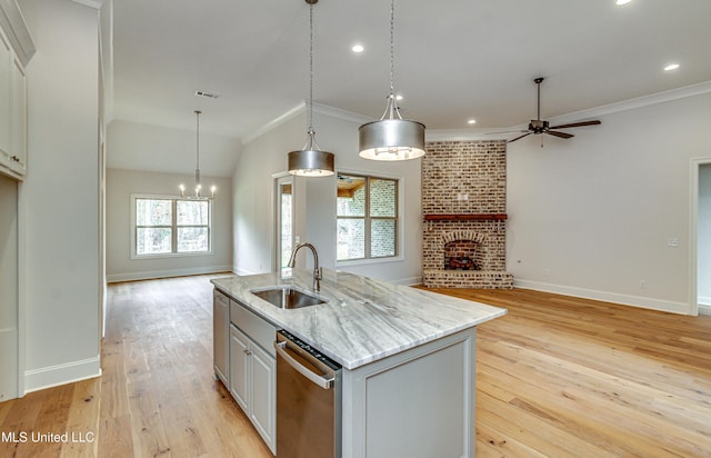 kitchen featuring light wood-type flooring, a fireplace, sink, a center island with sink, and dishwasher