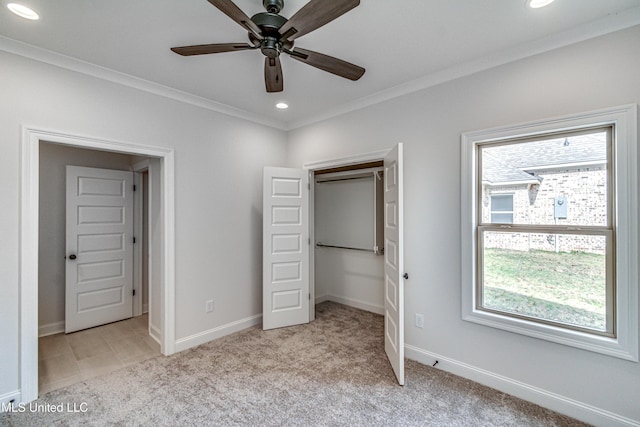 unfurnished bedroom featuring multiple windows, light colored carpet, ceiling fan, and crown molding