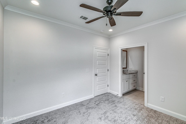 unfurnished bedroom with ceiling fan, crown molding, light carpet, and ensuite bath