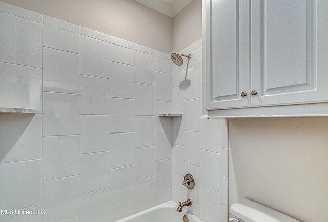 bathroom with tiled shower / bath combo and toilet